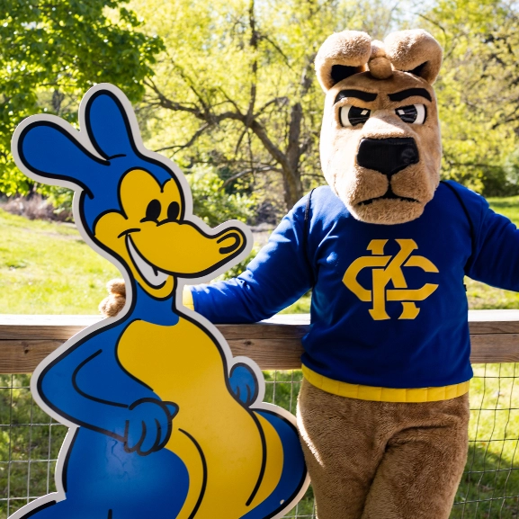 UMKC mascot, KC Roo poses with a cutout of UMKC's original Roo mascot illustrated by Walt Disney.