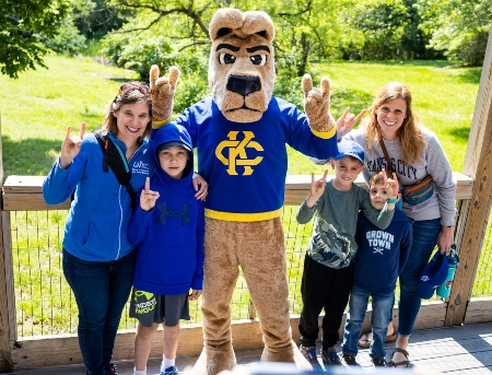 UMKC mascot, KC Roo, poses with zoo visitors in front of the kangaroo exhibit at the Kansas City Zoo.