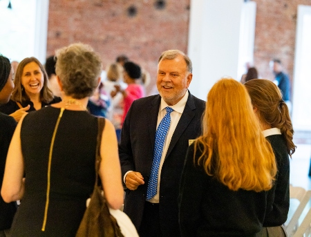 Faculty members talking and smiling at an awards event.