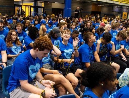 A group of new students standing and cheering during UMKC's convocation event.