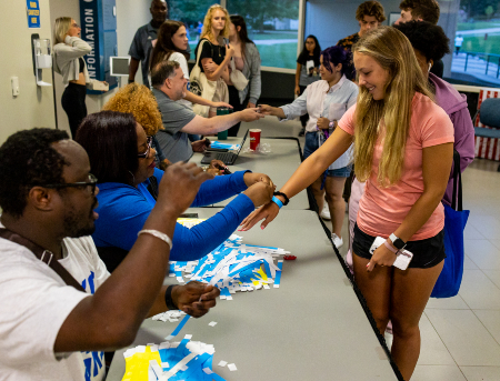 A group of students talking with an student affairs staff member at an event hosted by the Multicultural Student Affairs Office.