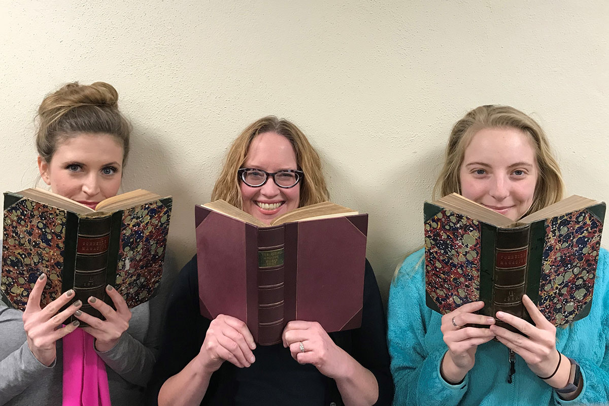 students and professor look at Victorian books